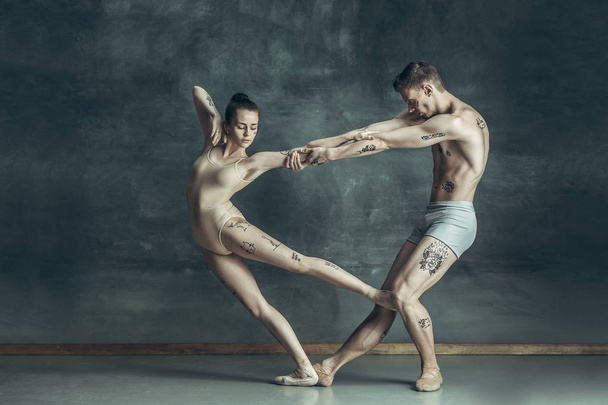 The young modern ballet dancers posing on gray studio background - Fotografie, Obrázek