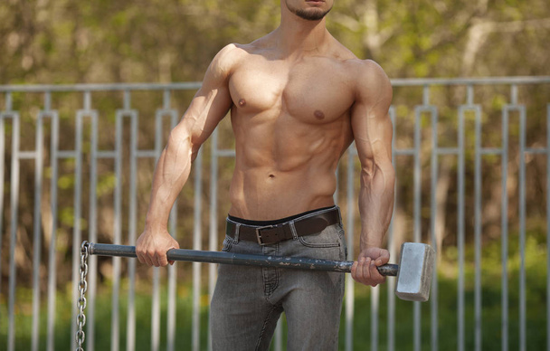Young Man Hits Tire - Workout Outdoors With Hammer - Fotografie, Obrázek