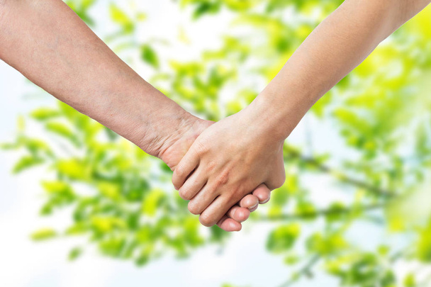 close up of senior and young woman holding hands - Photo, image