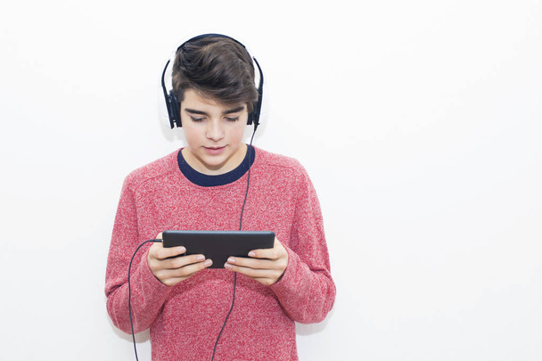 teenager with the tablet and headphones listening to music - Foto, imagen