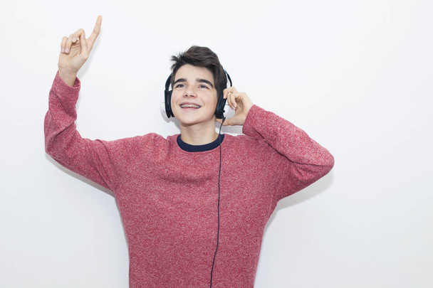 adolescente con auriculares bailando sobre fondo blanco
 - Foto, imagen