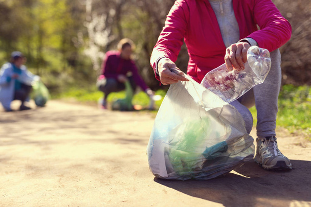Inspired volunteers gathering garbage in the park - Photo, Image