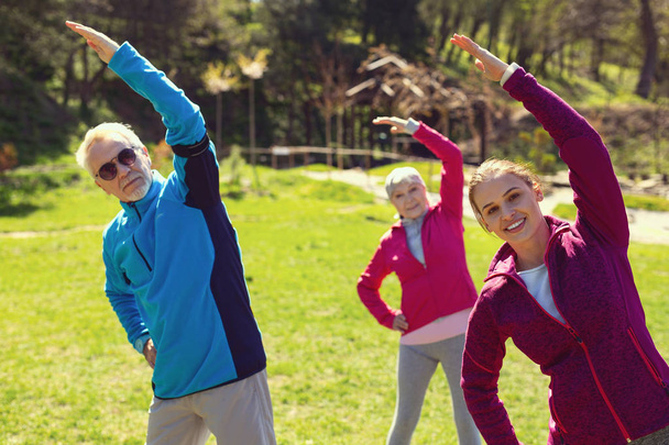 Szczęśliwych ludzi, robić ćwiczenia w parku - Zdjęcie, obraz