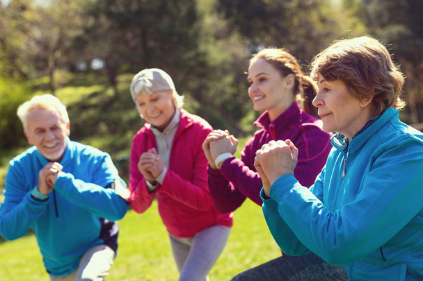 Feliz anciana haciendo ejercicio con sus amigos
 - Foto, imagen