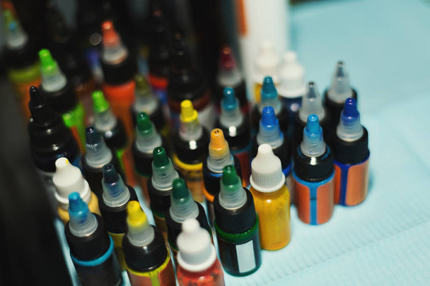 Meerdere flessen met kleurrijke inkten voor tattoo - Foto, afbeelding