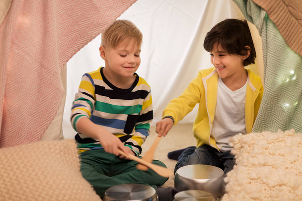 boys with pots playing music in kids tent at home - 写真・画像