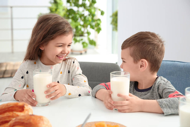 Petits enfants mignons petit déjeuner avec du lait à table
 - Photo, image