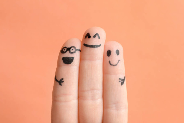 Fingers with drawings of happy faces against color background. Unity concept - Φωτογραφία, εικόνα