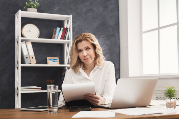Business woman reading document at office desktop - Фото, зображення