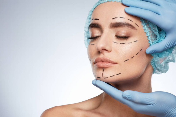 kauneusmuotokuva nainen, plastiikkakirurgia käsite. Malli sinisessä korkissa, jossa on reiät kasvoissa
 - Valokuva, kuva