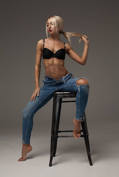 Beautiful and sexy blonde woman wearing lingerie and jeans - Fotografie, Obrázek