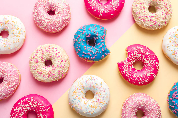 Delicious glazed doughnuts on color background, top view - Foto, afbeelding