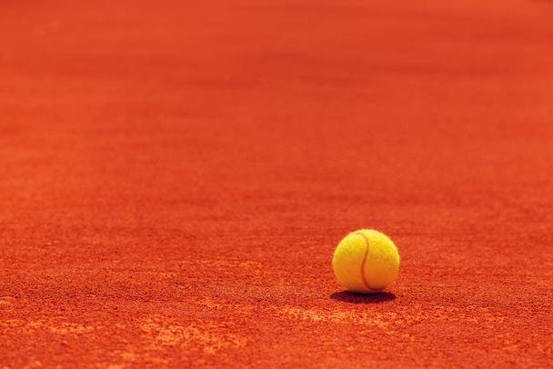 Μπάλα του τένις σε πηλό δικαστήριο, επιλεκτική εστίαση με κενό αντίγραφο χώρου - Φωτογραφία, εικόνα