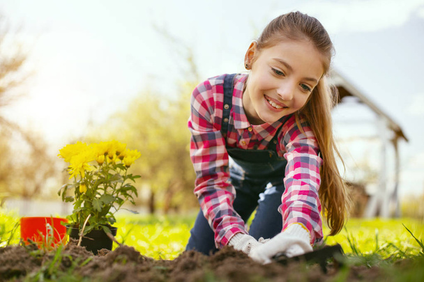 Joyful happy girl using gardening tools - Foto, afbeelding