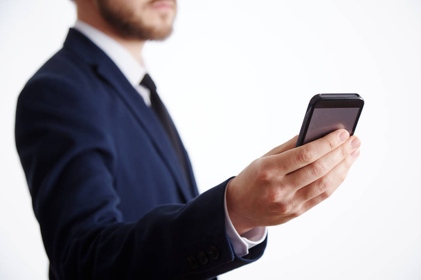 attractive man wearing suit holding mobile phone, business concept - Fotó, kép