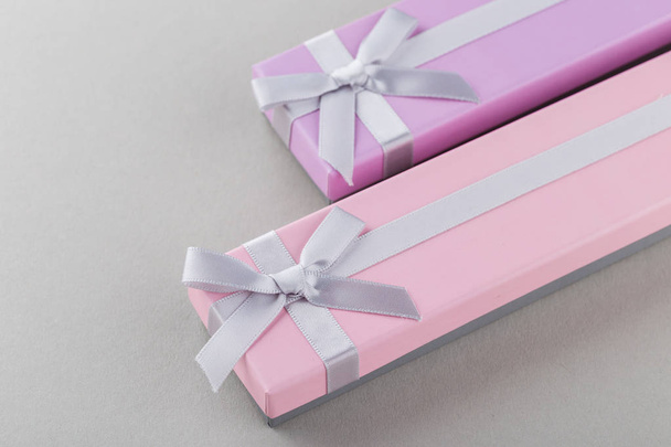 Pink and violet gift boxes with ribbon bows on gray background  - Foto, Imagem