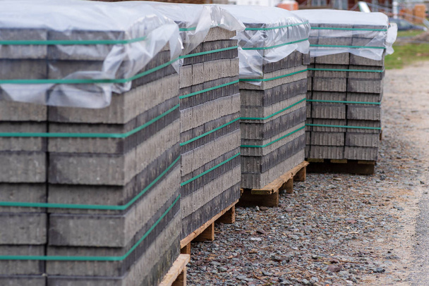 Pavimentación de piedras en varias paletas, cubiertas con papel de aluminio como protección contra la lluvia
 - Foto, imagen