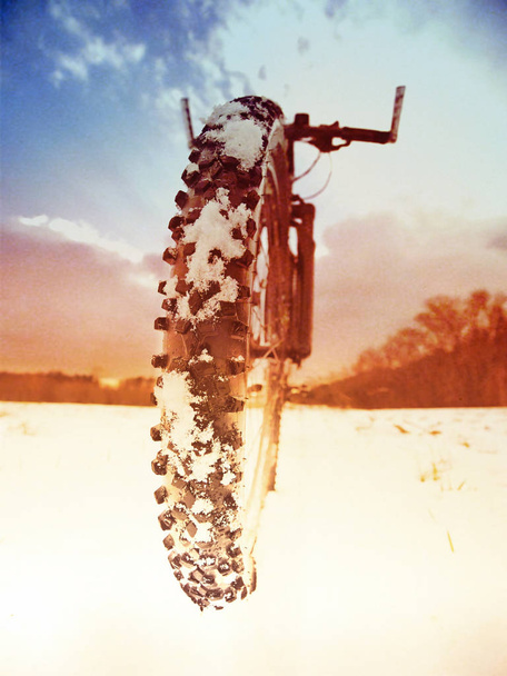 Effet abstrait. Détail vélo avant sur un sentier d'hiver, sentier couvert de neige. Milieux sportifs et nature morte. Faire du vélo à la campagne
. - Photo, image