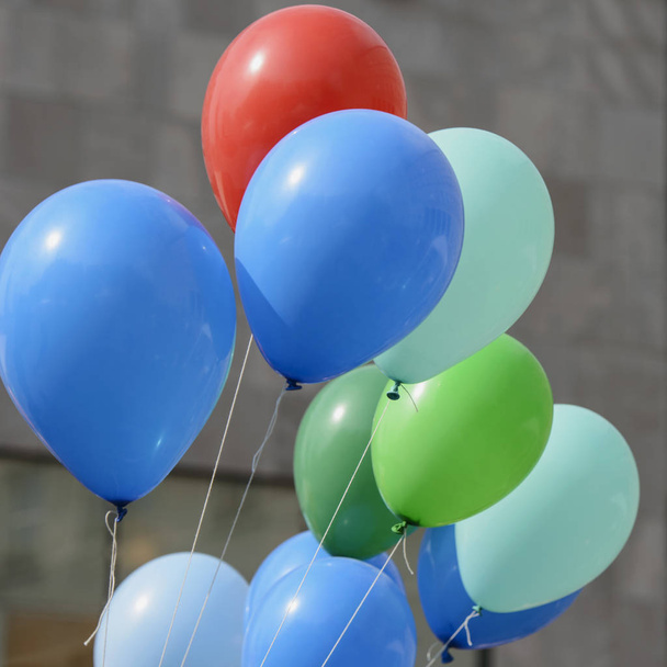 Πολύχρωμα μπαλόνια γεμάτα με αέριο ήλιο τείνουν να πετούν μέχρι - Φωτογραφία, εικόνα