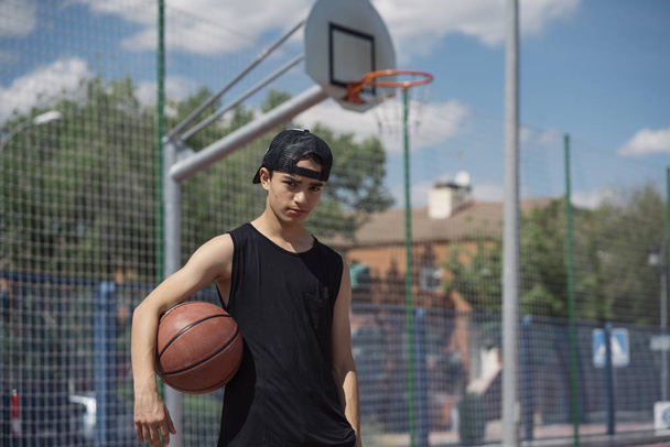 Молодой человек держит баскетбольный мяч
 - Фото, изображение