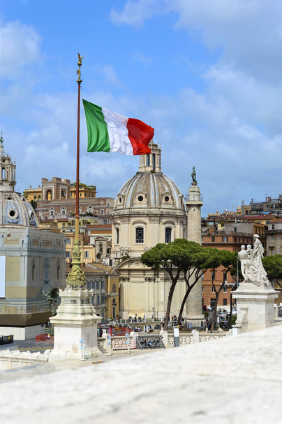 Nézd a National monument a Vittorio Emanuele át a templom a Santa Maria di Loreto, Ss Nome di Maria és Traianus-oszlop a Traianus fórum, közel a Piazza Venezia, Rome, Olaszország. Olasz zászló. - Fotó, kép