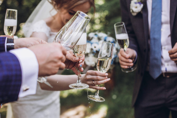 Счастливая компания людей, пьющих шампанское. Руки держат бокал шампанского. Подружки невесты и подружки жениха веселятся. Праздник. Праздник Рождества
 - Фото, изображение