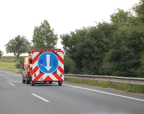 camión de servicio de la autopista que señala el carril con una gran flecha blanca
 - Foto, imagen