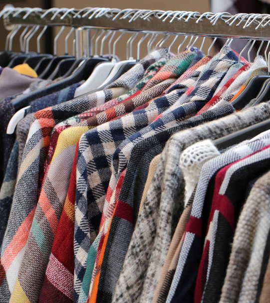 Много одежды в вешалках на блошином рынке подержанной одежды для продажи
 - Фото, изображение