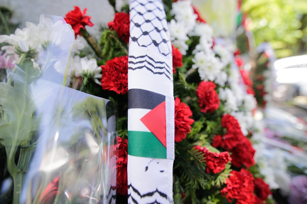 パレスチナの旗と歩道にろうそくが咲く花 - 写真・画像