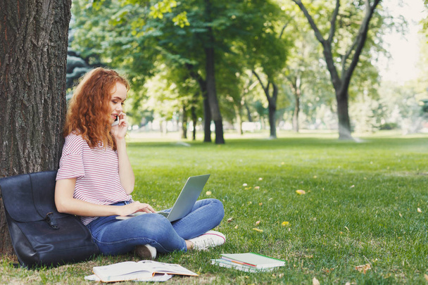 Ελκυστική φοιτητής με laptop και μικρόs φορήτοs σε εξωτερικούς χώρους - Φωτογραφία, εικόνα