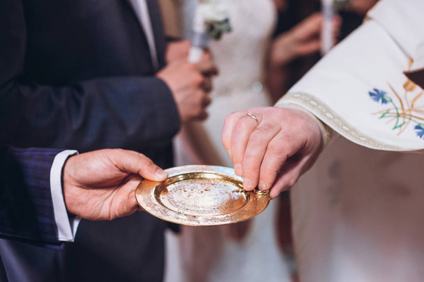 kněz golding zlaté snubní prsteny na desku v kostele v manželství svatba. tradiční svatební obřad - Fotografie, Obrázek