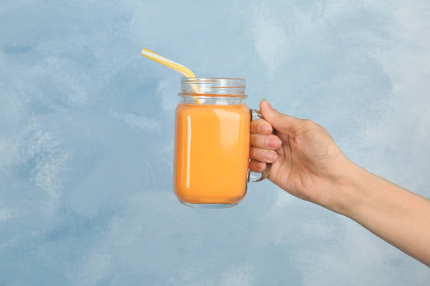 Woman holding mason jar with delicious smoothie on color background - Fotografie, Obrázek
