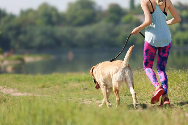 Young woman and her dog spending time together outdoors. Pet care - Photo, Image