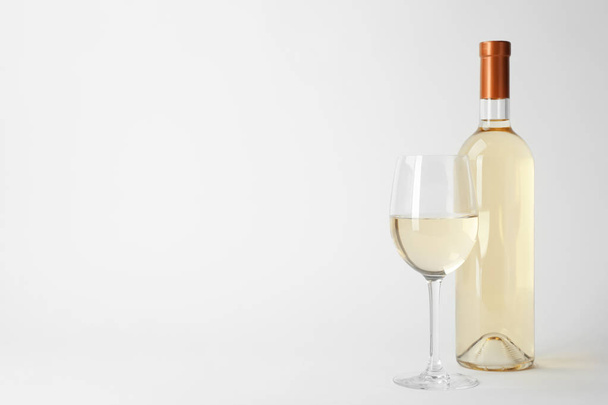 Flasche und Glas teurer Weißwein auf hellem Hintergrund - Foto, Bild