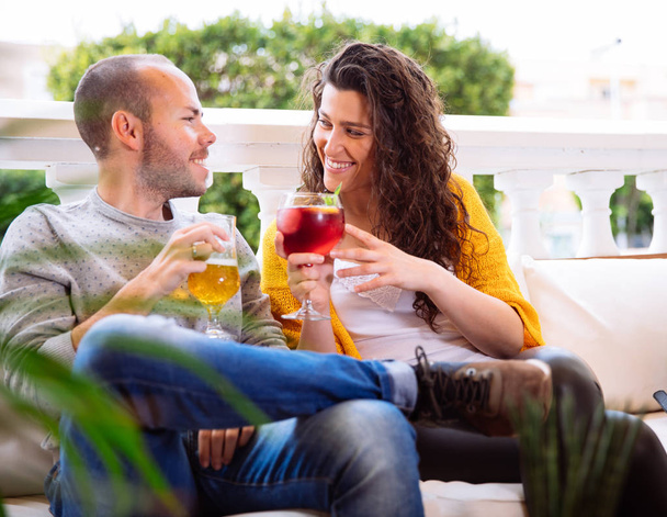 Happy couple or friends flirting talking and drinking in a restaurant terrace and looking each other. Love and youth concept  - Foto, imagen
