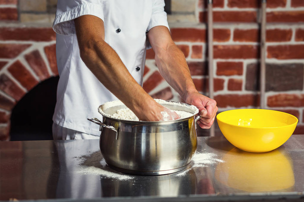 chef making dough for pizza. Man hands preparing bread. Concept of baking and patisserie - Photo, Image