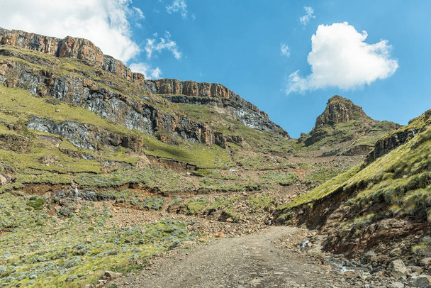 De haarspeldbochten in de Sani Pass. Voertuigen met vierwiel aandrijving zijn zichtbaar in de rug - Foto, afbeelding