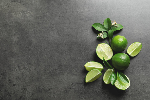 Composition with fresh ripe limes on gray background, top view - Foto, Bild