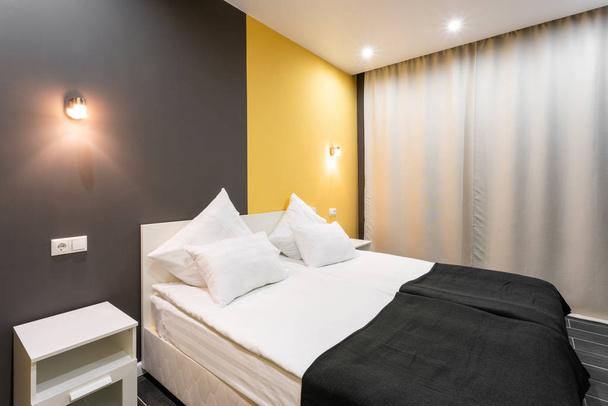 Δωμάτιο Hotel standart. μοντέρνα κρεβατοκάμαρα με λευκά μαξιλάρια. απλό και κομψό εσωτερικό. Εσωτερικός φωτισμός - Φωτογραφία, εικόνα