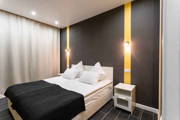 Quarto de hotel standard. quarto moderno com almofadas brancas. interior simples e elegante. iluminação interior
 - Foto, Imagem
