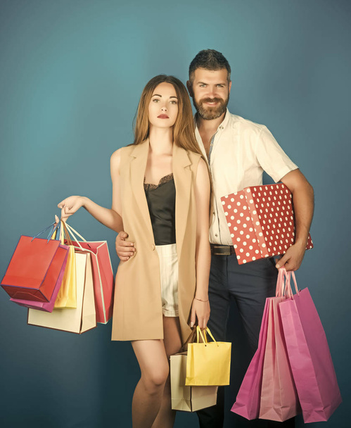 Couple in love hold shopping bag near blue wall. - Foto, afbeelding