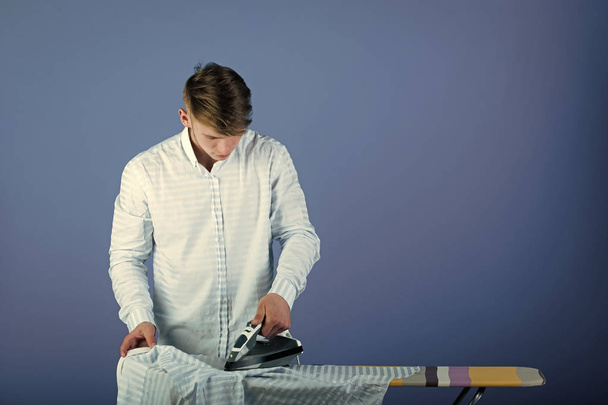Serious man. Man ironing clothes - Foto, Bild