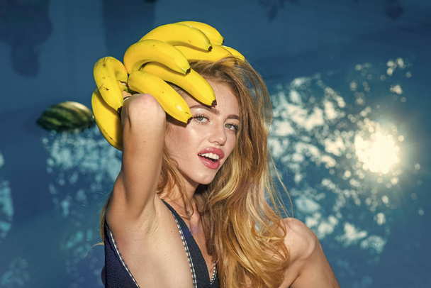 Dieting and healthy organic food, vegetarian. Vitamin in banana at girl near water. Woman relax in spa luxury swimming pool. Sexy woman with tropical fruit in pool. Sensual woman. - Photo, image
