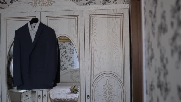 Eine Herrenjacke hängt an einem Kleiderbügel im Zimmer - Filmmaterial, Video