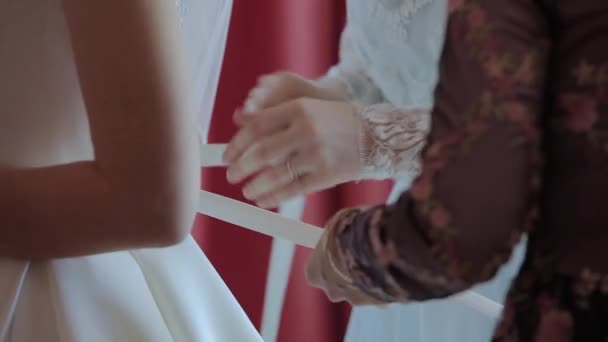 Mann bindet Brautkleid der Braut ein Korsett an - Filmmaterial, Video