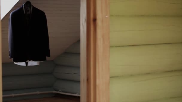 Una giacca da uomo appesa ad un appendiabiti nella stanza
 - Filmati, video
