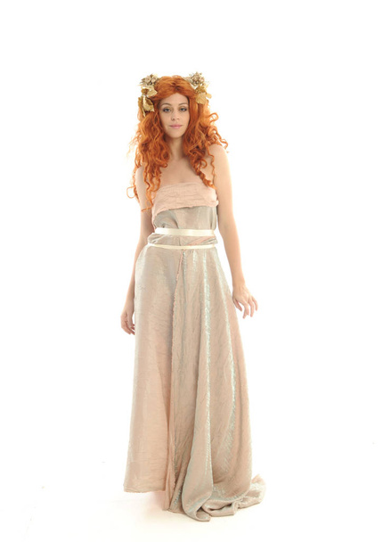 full length portrait of pretty red haired lady wearing fantasy toga gown, standing pose on white background. - Photo, Image