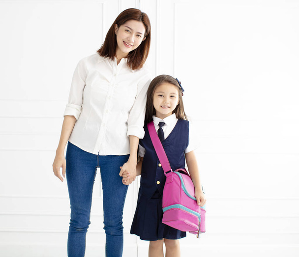 Мать держит за руку дочь готова идти в школу
  - Фото, изображение