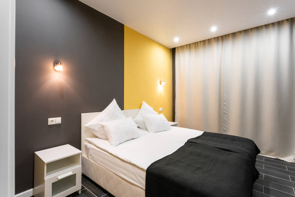 A Hotel standart szoba. modern hálószoba fehér párnák. egyszerű és elegáns belső tér. belső világítás - Fotó, kép