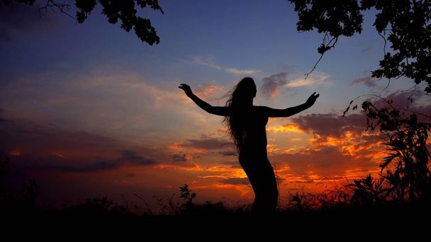 Meisje zwarte schaduw doen yoga, vrouwelijke silhouet in de hemelachtergrond avond. - Foto, afbeelding